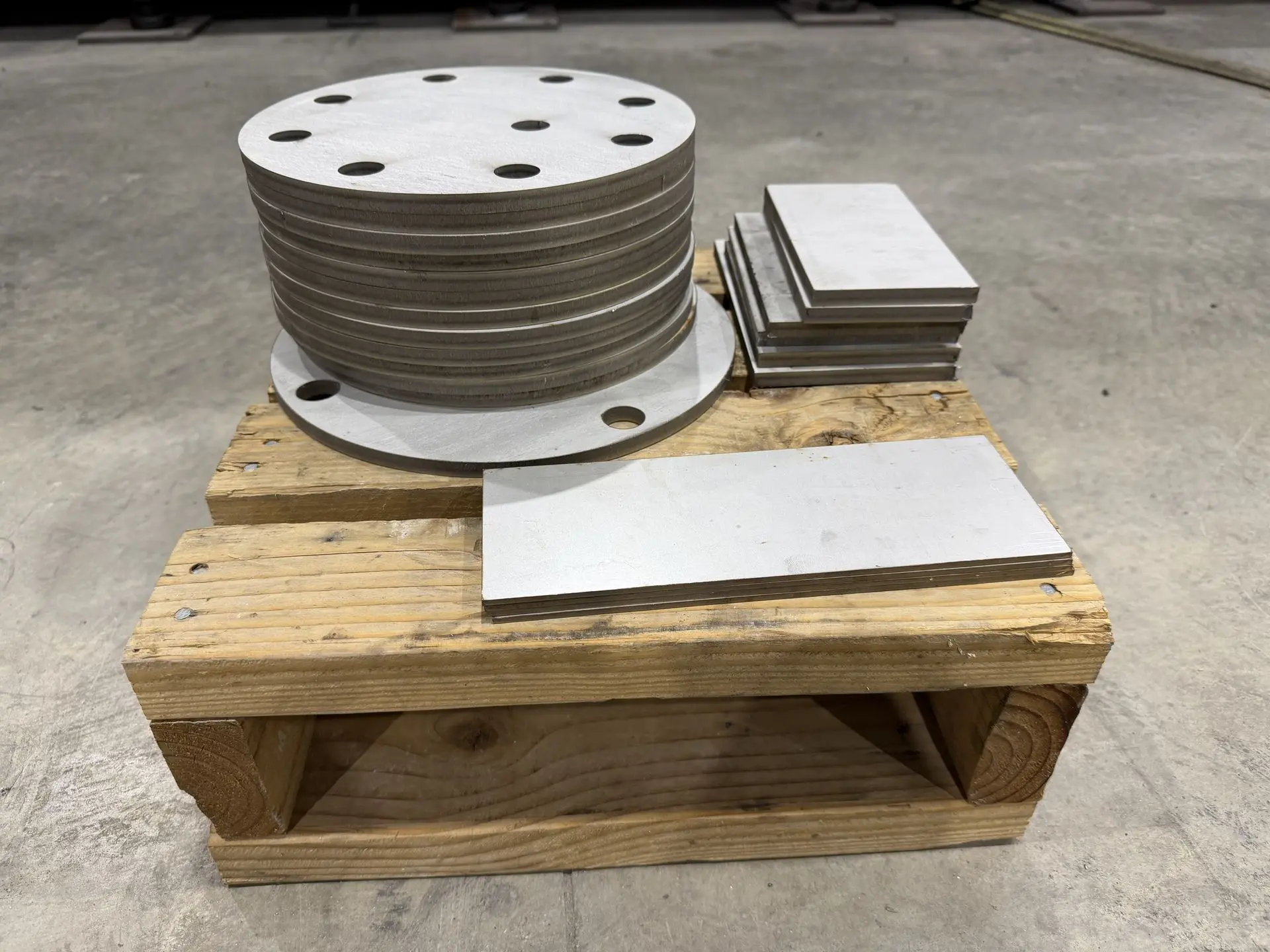 A batch of round plates with hole patterns and rectangular metal plates made at Rapid CNC Parts.